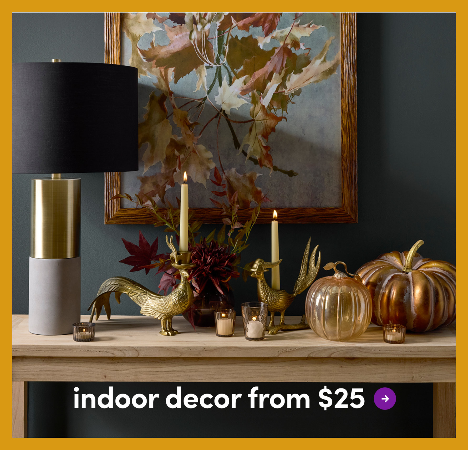 Fall-themed console table featuring a modern lamp, gold pheasant candle holders, and decorative pumpkins with the text indoor decor from $25.
