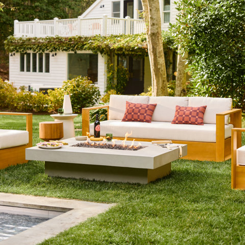 Outdoor living space with sofa, fire pit, and pool.