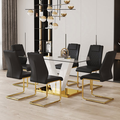 Ensemble de table et de chaises. Ensemble de salle à manger en verre trempé transparent de luxe subtil avec 6 chaises en polyuréthane noir avec pieds en métal en C doré. Ajoutant une atmosphère chaleureuse et douce à votre famille.