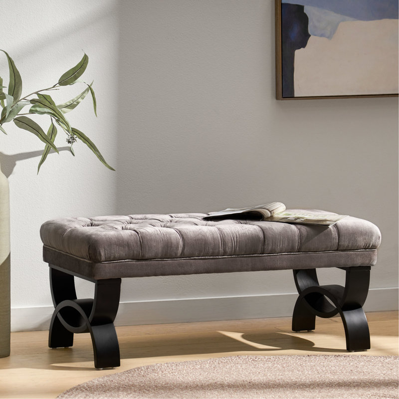 Banc moderne en velours gris avec pieds élégants et courbes pour une utilisation polyvalente dans votre maison