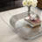 Kaydae Glass Top Coffee Table with Sculptural Aluminum Base in Antique Brass