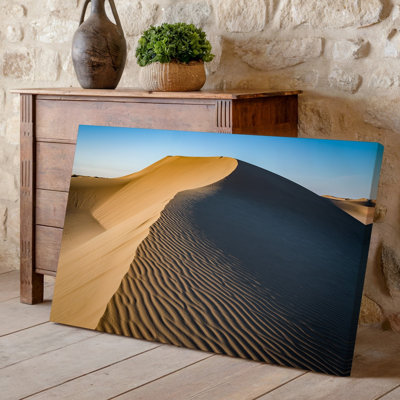 Toile, "Un vaste paysage de désert avec une dune de sable éminente que l'art mural gracieusement contre un ciel bleu clair"