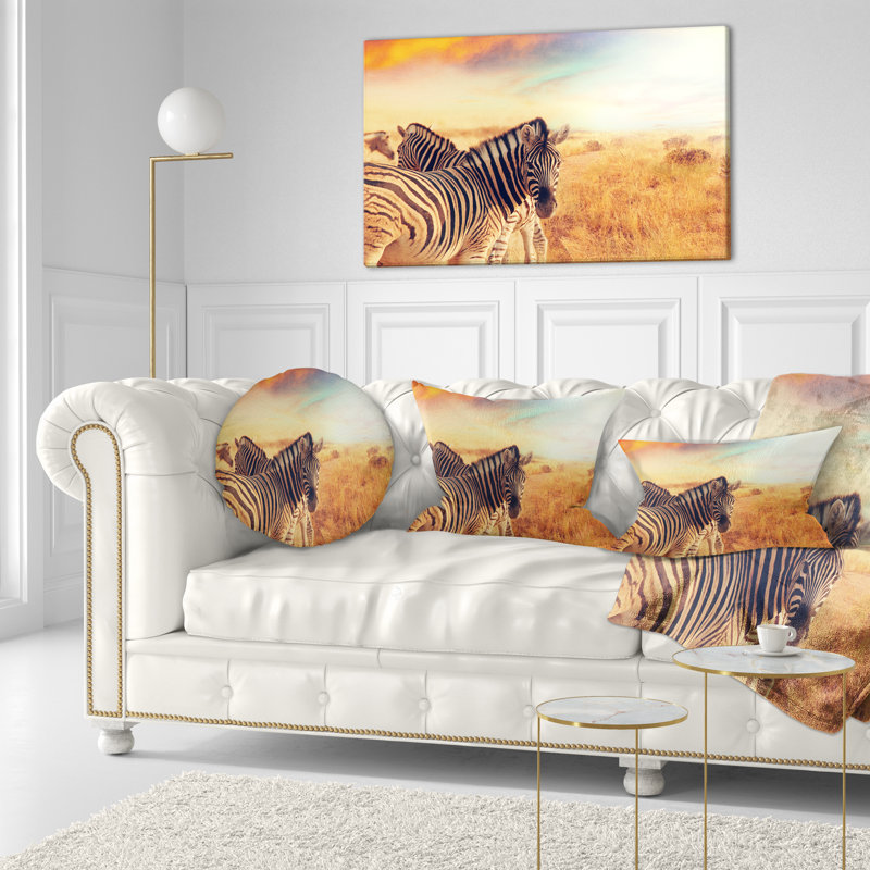 Coussin lombaire zèbres de troupeau dans le terrain sur le coucher du soleil