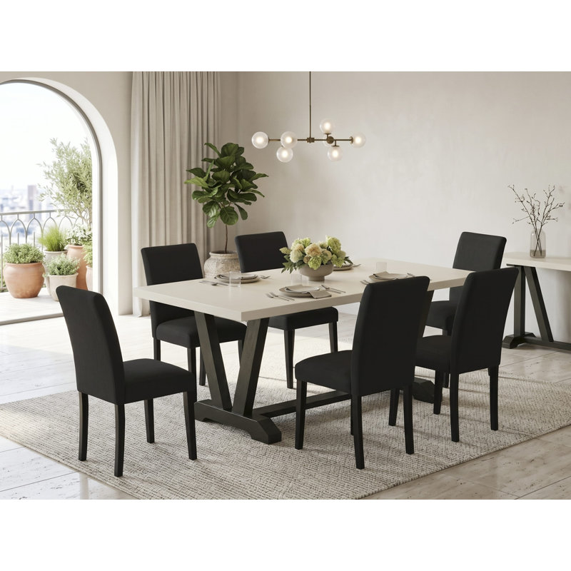 L'ensemble de 7 pièces de salle à manger se compose d'une table de salle à manger rectangulaire Jacobean patinée avec des pieds en V et de 6 chaises rembourrées en tissu de lin noir, finition noire brossée