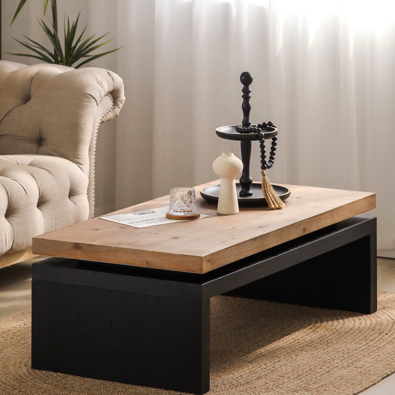 La table basse en bois massif noir et naturel, avec un bureau de salon rustique, ajoute du charme