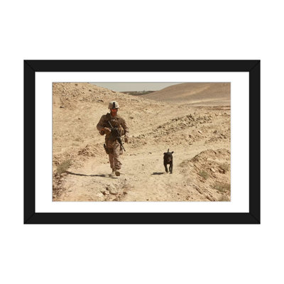 «A Dog Handler Walks with an Explosives Detection Dog pendant une patrouille», reproduction de photo sur toile