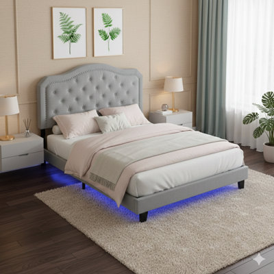 Lit rembourré avec une silhouette gracieusement courbée et des accents capitonnés - Repose sur une base de lattes en bois massif - Assemblage simple - Finition en velours gris clair - Comprend un éclairage à DEL intégré - Conçu comme un lit plateforme - Quee