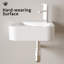Lavabo de salle de bain mural compact en céramique avec robinet et bonde, idéal pour les conceptions modernes et peu encombrantes.