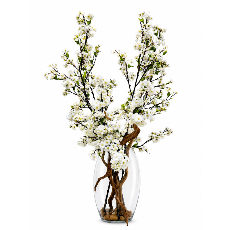 Grandes branches de cerisier en fleurs dans un vase en verre