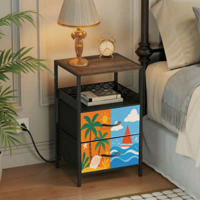 Table de chevet à 2 tiroirs avec station de recharge, ports USB, prises électriques et tablette de rangement ouverte. Motifs colorés : palmiers, soleil, voiliers, arbres. Parfait pour une chambre, un salon, une résidence étudiante ou un petit espace.