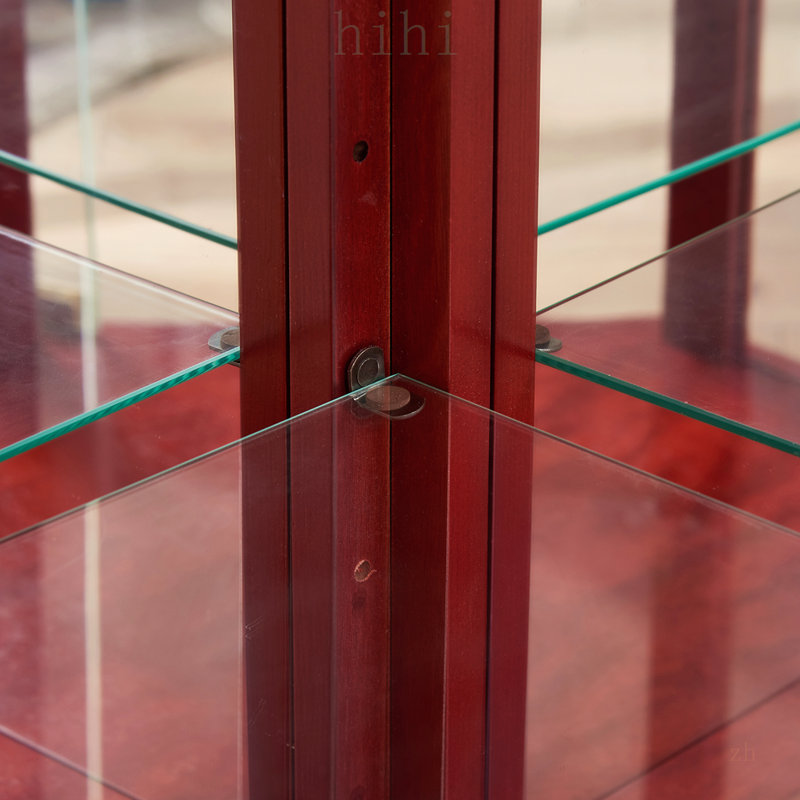Vitrine d'angle en verre avec tablettes réglables et élégante décoration sculptée, idéale pour exposer des objets de collection et des vins