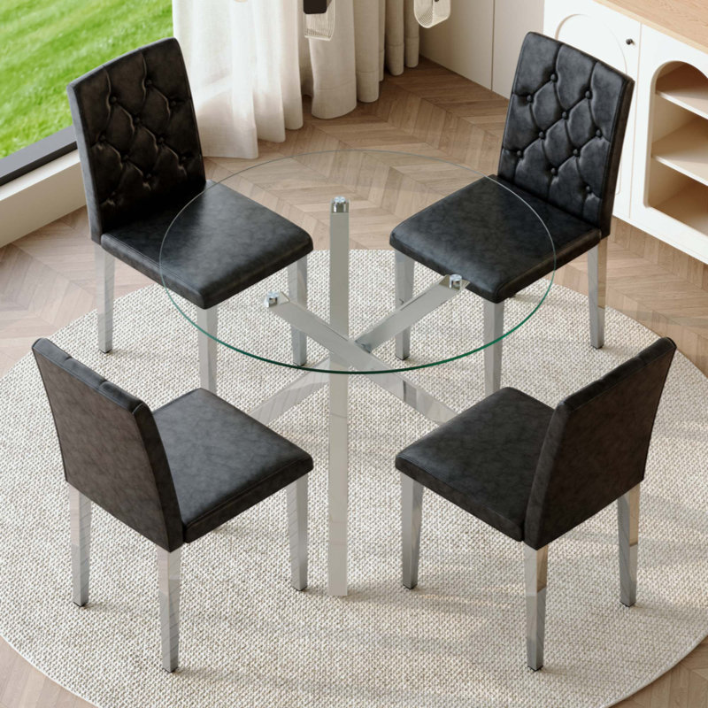 Ensemble de table et de chaises. Table ronde en verre moderne: 39 po de diamètre, support en métal argenté en forme de X. Jumelé avec 4 chaises de salle à manger en polyuréthane noir avec dossier ergonomique à boucle. Convient aux restaurants et aux cuisines.