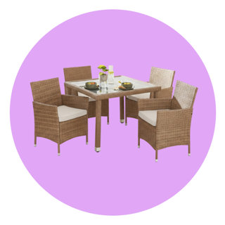 Four-piece rattan patio dining set with a square glass-top table and chairs with cream cushions.