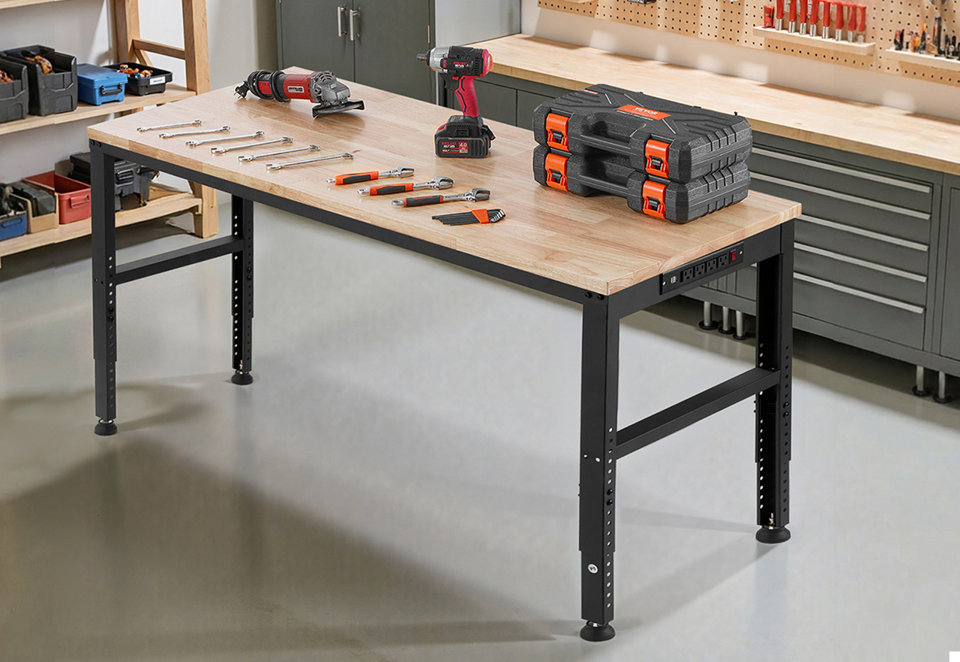 Adjustable height steel workbench with a light wood top and built-in power strip in a workshop setting with tools displayed on the surface.