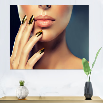 Modèle féminin avec maquillage doré et clous noirs - photographie sur toile