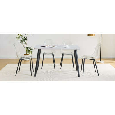 Ensemble de table et de chaises. Table de salle à manger rectangulaire moderne. Comptoir en verre trempé blanc + panneau inférieur en panneau de fibres à densité moyenne. Assorti de 4 chaises en plastique transparent avec des pieds en métal noir. Apportez une expérience confortable à la maison.