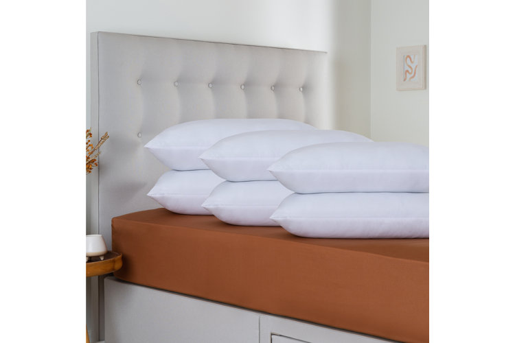 stacks of bed pillows piled up on a bed
