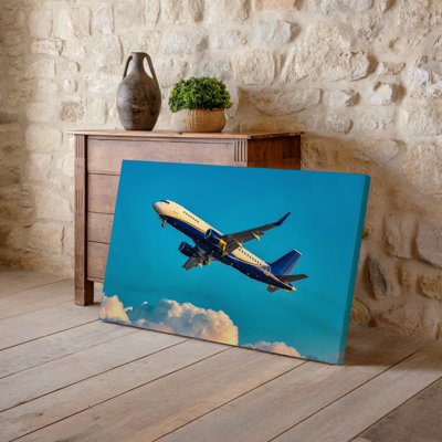 Canvas A Bright Sunny Sky Serves As The Backdrop For A Wall Art Commercial Airplane Soaring Above Fluffy White Clouds Capturing A Canvas Wall Art
