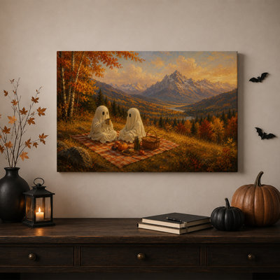 Deux fantômes pique-niquant avec des citrouilles et une toile murale d'Halloween enneigée