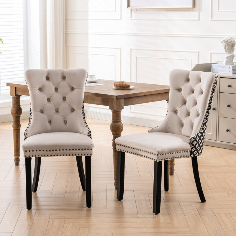 De 2 chaises de salle à manger en velours beige. Revêtement contemporain en bois massif. Conception avec garniture cloutée. Dossier haut confortable. Rivets décoratifs pour l'élégance. Coussin en mousse Rebond. Cadre, 280 lb