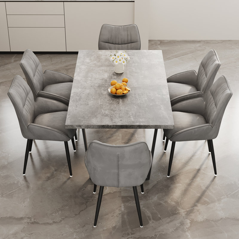 Élégante table de salle à manger en MDF gris et chaises en velours pour des rassemblements confortables