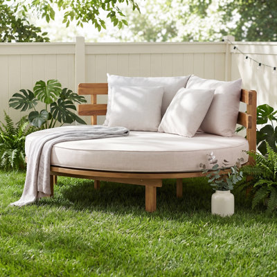 Lit de jour extérieur en bois rond avec dossier à lattes incurvé, coussin et 4 coussins