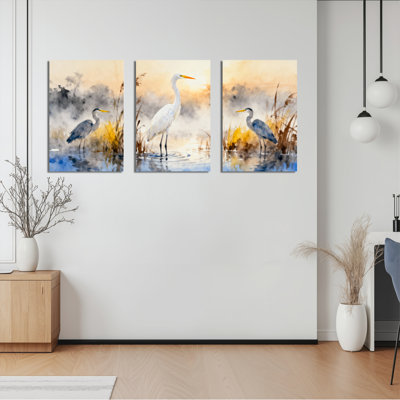 Ensemble de 3 tableaux sur toile tendue représentant des hérons dans un paysage de marais brumeux
