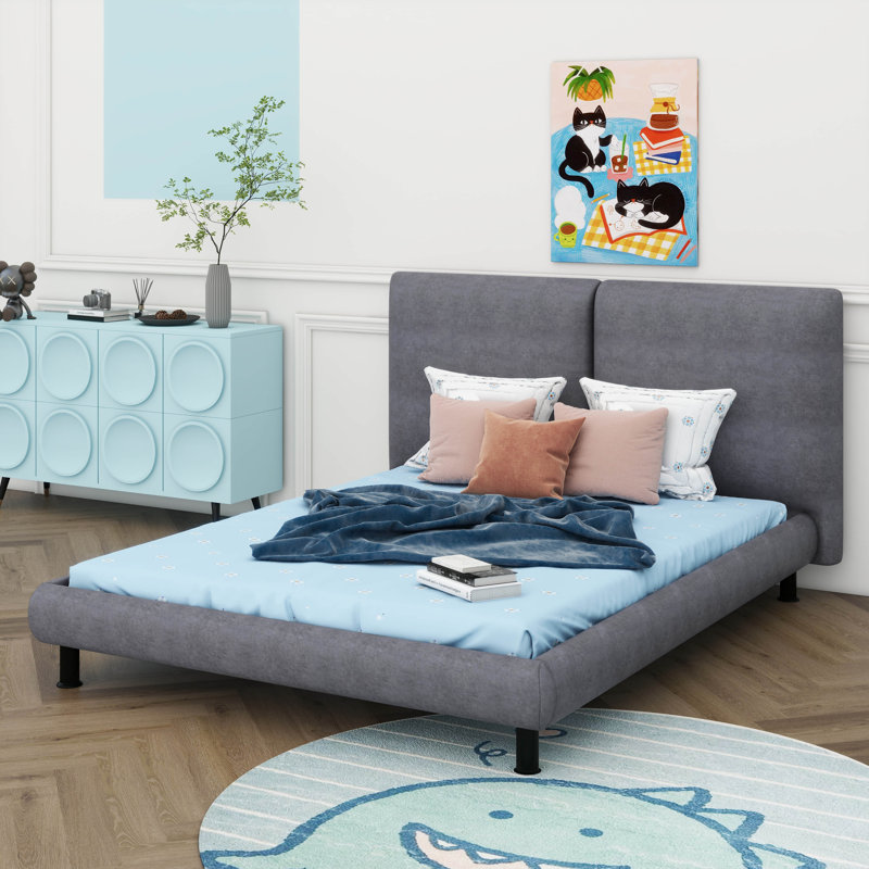 Un grand lit plateforme tapissier doté de deux grands appuis-tête confortables et recouvert d'un tissu épais et luxueux, Gris