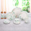 Théière en porcelaine et feuilles vertes