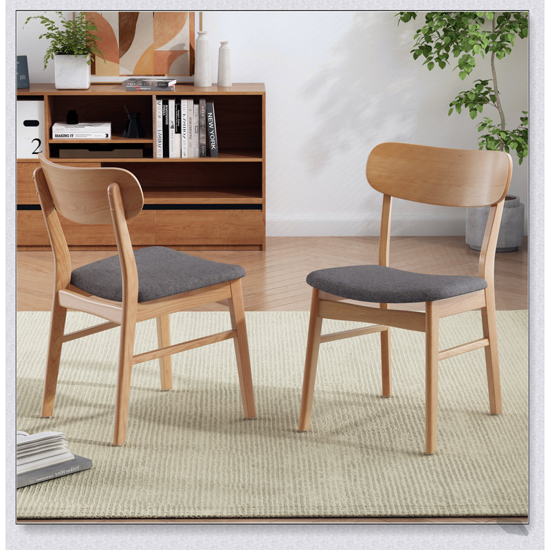 Chaise de salle à manger confortable en tissu avec coussin épais et structure en bois durable, parfaite pour les expériences culinaires élégantes et confortables.