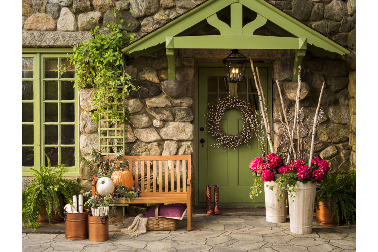 bright green front porch with a wood bench and two planters of dark pink hydrangeas