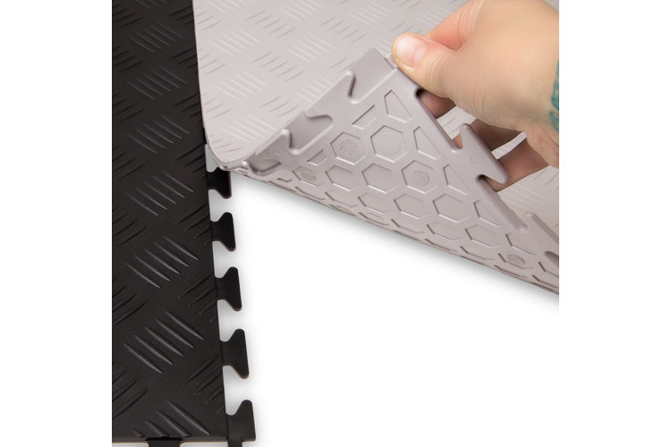 black and white interlocking garage tiles being placed together