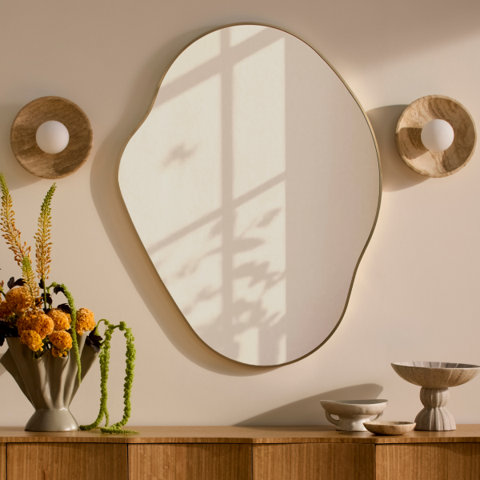Irregularly shaped mirror with light sconces.