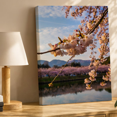 Toile d'un paysage serein avec de délicates branches de cerisiers en fleurs ornées de fleurs roses douces se courbant gracieusement sur une toile
