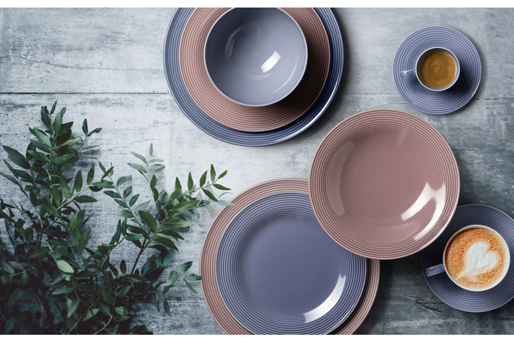 blue and brown dinnerware on a blue table with a plant