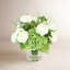 Renoncule, hortensia et herbe disposés dans un vase en verre