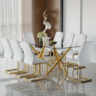 Ensemble de table et de chaises. Ensemble de table de salle à manger moderne et luxueux en verre trempé transparent avec 8 chaises. Pieds de table en métal doré à double fourche.