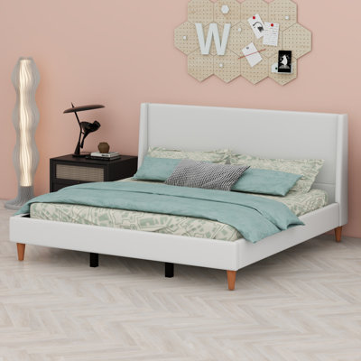 Lit plateforme tapissier avec tête de lit à oreilles et pieds en bois