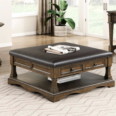 Table basse traditionnelle brune avec 4 tiroirs de rangement, une tablette ouverte et facile à déplacer pour un espace de vie pratique. Plateau rembourré de couleur café.