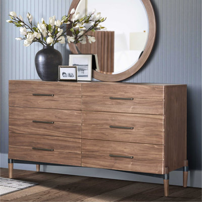 La commode et la commode avec une finition en bois clair et des poignées foncées minces allient simplicité moderne et rangement spacieux pour la chambre à coucher