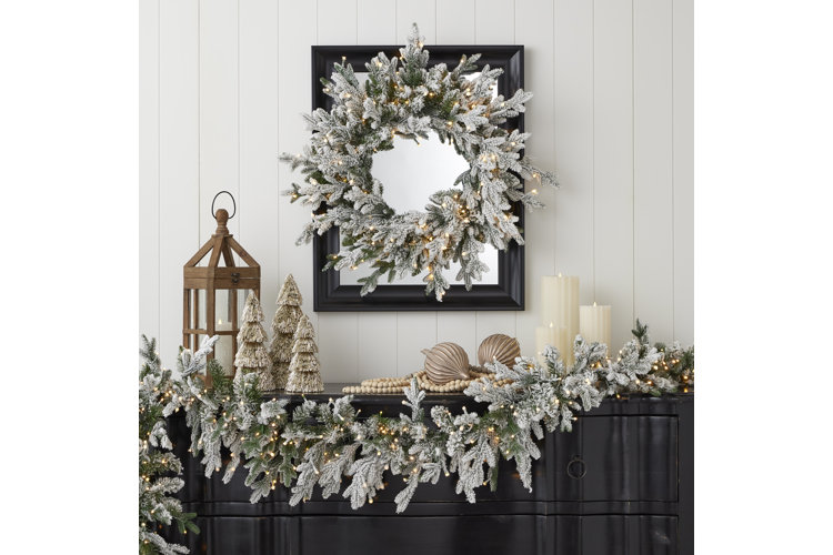 Elegant winter white Christmas decor with frosted wreath, garland, and silver accents