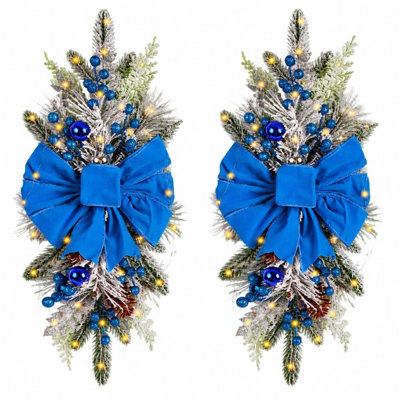 Lot de 2 guirlandes lumineuses artificielles en forme de larme pour porte d'entrée, floquées et décorées d'un nœud bleu, de boules bleues et de pommes de pin. Décoration hivernale pour murs, fenêtres et porches.