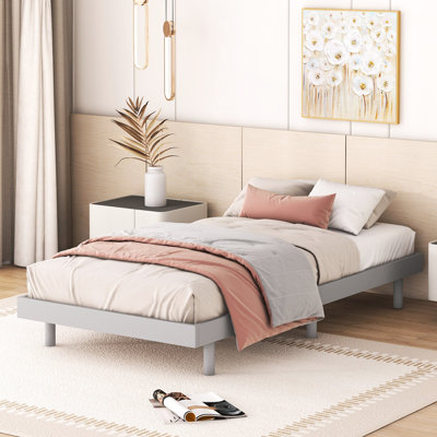 Lit simple gris au style contemporain et aérien, posé sur une plateforme pour transformer votre chambre.