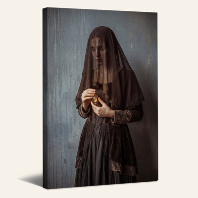 Femme au voile sombre tenant un pendentif sur fond de toile bleue d'Halloween