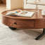 Table basse ronde moderne en noyer de 90 cm (35,4 po) avec tiroir de rangement, plateau en placage de bois et pieds sphériques sculpturaux.