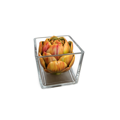 Arrangement floral de faux artichauts dans un vase carré en verre transparent et de l'eau artificielle, décoration de table réaliste