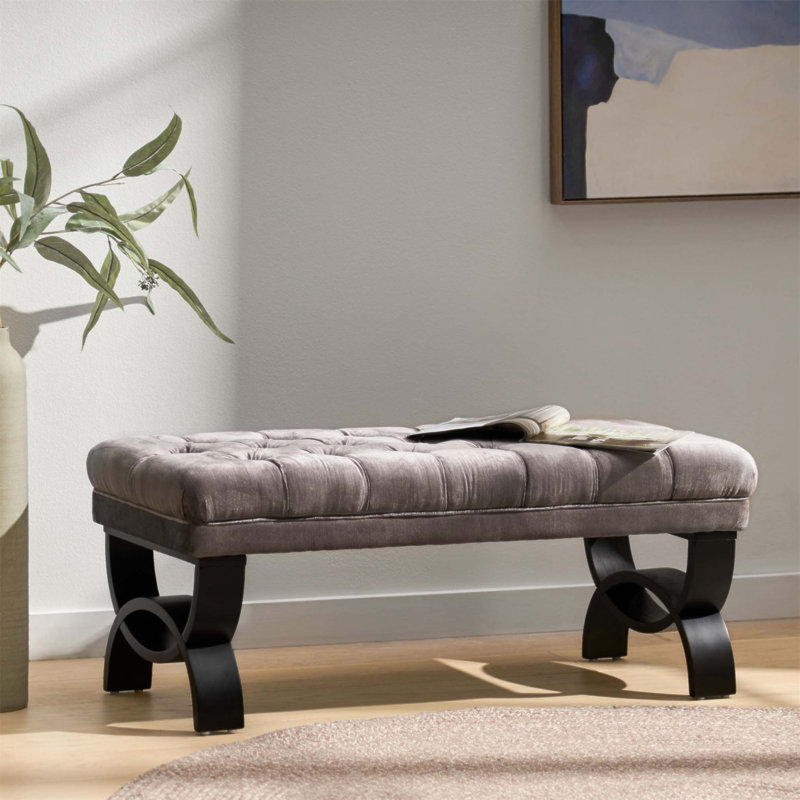 Luxueux repose-pieds capitonné classique avec coutures en losanges et pieds semi-circulaires modernes pour une décoration intérieure élégante
