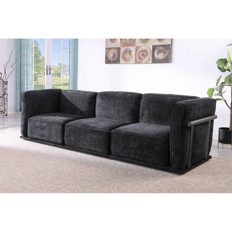 Ceci est un ensemble de canapé modulaire en tissu, comprenant un module d'angle et plusieurs sièges indépendants, jumelé avec des repose-pieds carrés du même matériau.