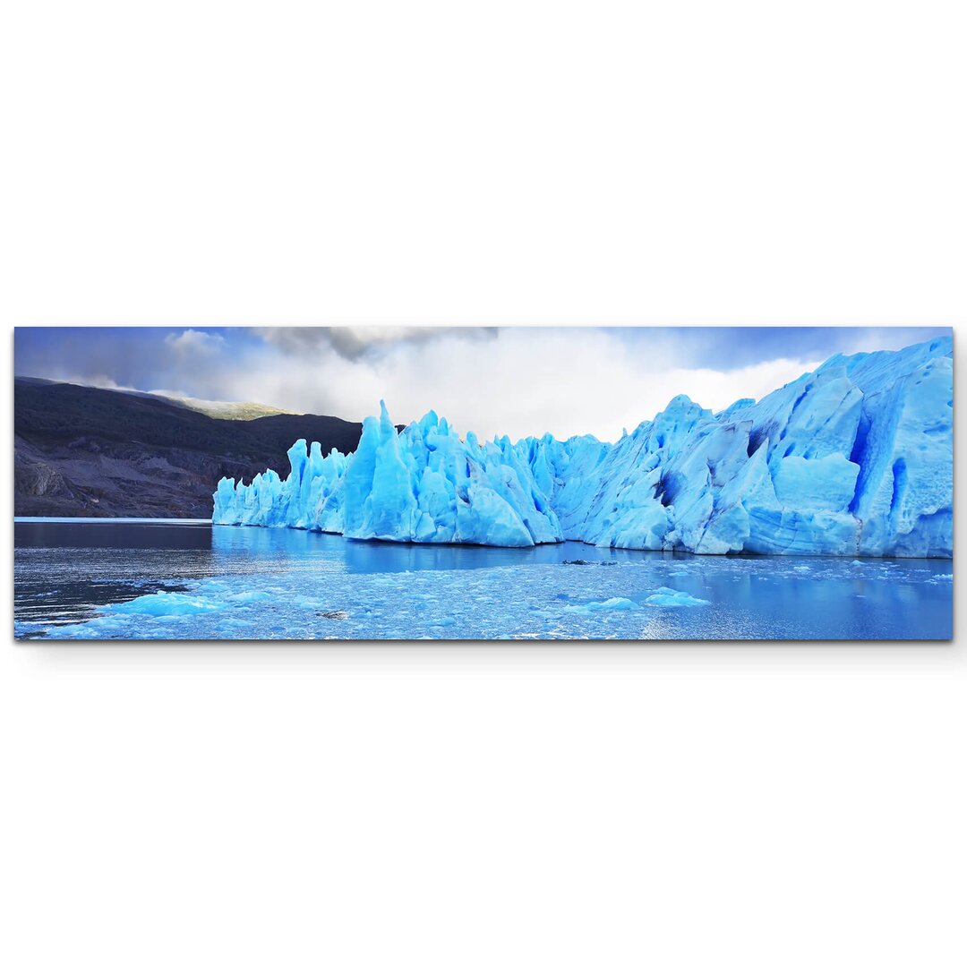 Leinwandbild Blauer Eisberg im Wasser in Argentinien