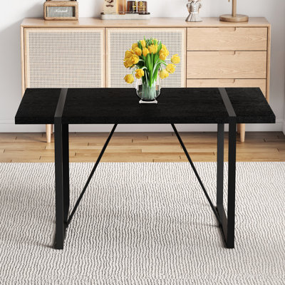 Table de salle à manger minimaliste de 55 pouces avec des pieds rectangulaires en métal noir et un plateau texturé, ajoutant une touche artistique aux pieds supérieurs de la maison, offrant un environnement confortable